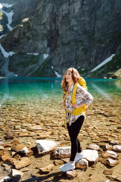 Kobieta Turystka Jasnożółtym Plecakiem Stoi Pobliżu Alpejskiego Jeziora Pośród Górskich — Zdjęcie stockowe
