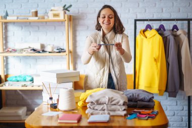 İşyerindeki dijital tabletli mutlu küçük işletme sahibi. Genç bir iş kadını giyim mağazasından siparişleri kontrol ediyor. Alışveriş konsepti, moda.