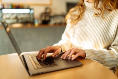 Dizüstü bilgisayarda yazı yazan kadınların yakın çekimi. Rahat bir kafede dizüstü bilgisayarda çalışan bir kadın. Serbest çalışma kavramı, uzak çalışma..