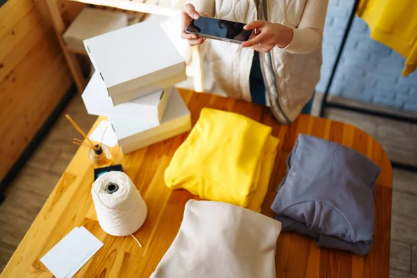 İşyerindeki dijital tabletli mutlu küçük işletme sahibi. Genç bir iş kadını giyim mağazasından siparişleri kontrol ediyor. Alışveriş konsepti, moda.