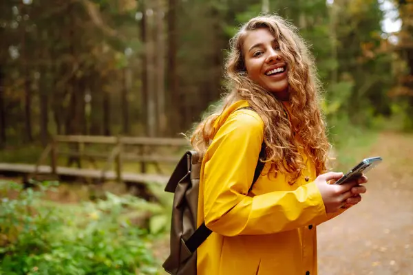 Jovem Viajante Uma Capa Chuva Amarela Segurando Telefone Suas Mãos — Fotografia de Stock