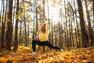 Güzel bir kadın sonbahar ormanında yoga yapıyor. Yaşam tarzı ve meditasyon konsepti.