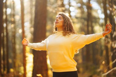 Güzel bir kadın sonbahar ormanında yoga yapıyor. Yaşam tarzı ve meditasyon konsepti.
