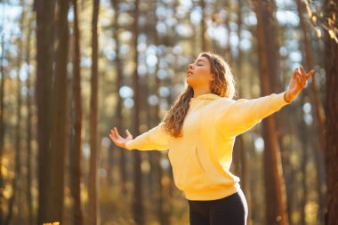 Güzel bir kadın sonbahar ormanında yoga yapıyor. Yaşam tarzı ve meditasyon konsepti.