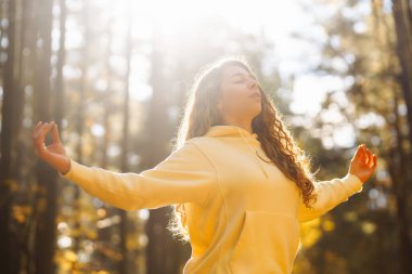 Güzel bir kadın sonbahar ormanında yoga yapıyor. Yaşam tarzı ve meditasyon konsepti.