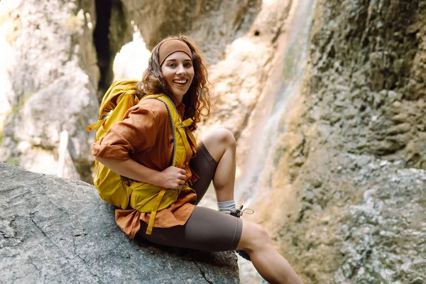 Uśmiechnięta Podróżniczka Żółtym Plecakiem Ubrana Piesze Ubrania Korzysta Wodospadu Pobliżu — Zdjęcie stockowe