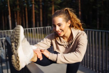 Kentsel bir ortamda spor yapan fitness kadını. Özel kıyafetli bir spor kadını egzersiz yapar. Aktif yaşam tarzı, eğitim. Yaşam biçimi.