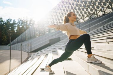 Kentsel bir ortamda spor yapan fitness kadını. Özel kıyafetli bir spor kadını egzersiz yapar. Aktif yaşam tarzı, eğitim. Yaşam biçimi.