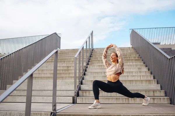 Kentsel bir ortamda spor yapan fitness kadını. Özel kıyafetli bir spor kadını egzersiz yapar. Aktif yaşam tarzı, eğitim. Yaşam biçimi.