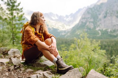 Yürüyüş botu. Yürüyüş parkurunda, açık bir dağın tepesinde, yürüyüş botlarıyla kadın bacaklarının yakın çekimi. Seyahat, tatil konsepti.