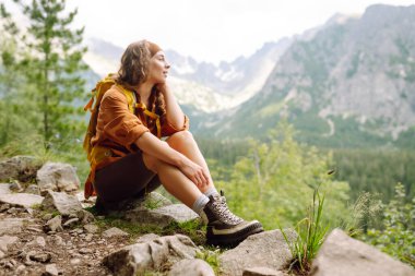 Yürüyüş botu. Yürüyüş parkurunda, açık bir dağın tepesinde, yürüyüş botlarıyla kadın bacaklarının yakın çekimi. Seyahat, tatil konsepti.
