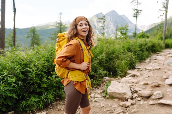 Kobieta Podróżuje Szlakiem Turystycznym Wśród Gór Żółtym Plecakiem Bucikami Turystycznymi — Zdjęcie stockowe