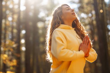 Genç bir kadın sonbahar ormanında, düşmüş yapraklar üzerinde yoga egzersizleri yapıyor. Yaşam tarzı, meditasyon konsepti. Eğleniyorum..