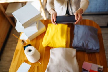 Giysi dükkanındaki şık kadın eşyaları kontrol ediyor, internetten sipariş veriyor. Çevrimiçi alışveriş konsepti, küçük işletme. Alışveriş konsepti.