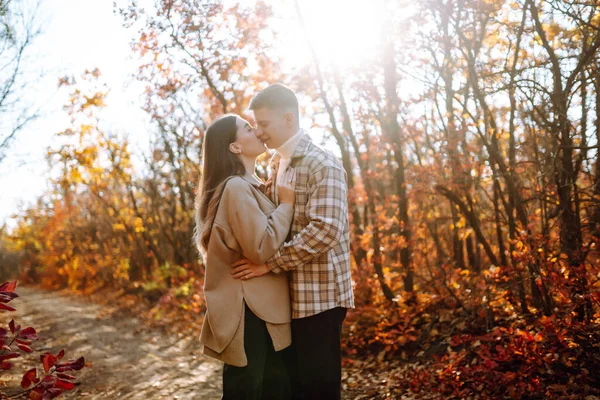 若い男性と女性は 秋の森で一緒に時間を過ごしています 秋に自然を楽しむ美しいカップル スタイル ファッション リラクゼーションのためのコンセプト — ストック写真