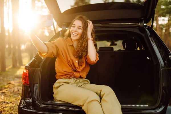 Young Woman Admires Sunset Trunk Car Phone Her Hands Curly — Stock Photo, Image