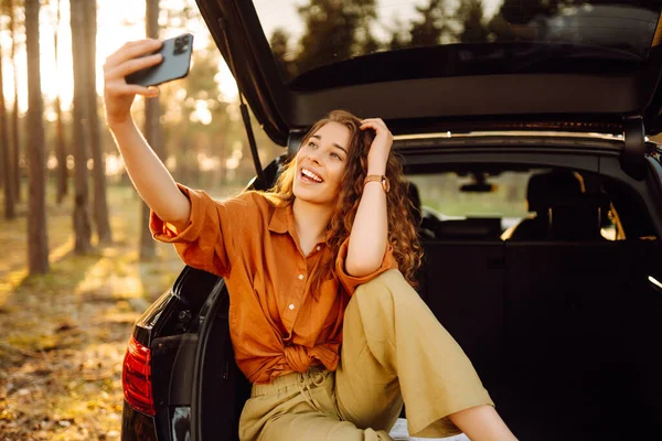 Young Woman Admires Sunset Trunk Car Phone Her Hands Curly — Stock Photo, Image