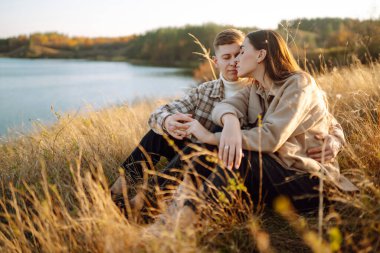 Gündelik kıyafetlerle gezen, termostan çay içen, ormanda sonbahar havasının tadını çıkaran bir çift. Tatil kavramı, hafta sonu, aşk.
