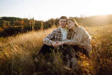 Gündelik kıyafetlerle gezen, termostan çay içen, ormanda sonbahar havasının tadını çıkaran bir çift. Tatil kavramı, hafta sonu, aşk.