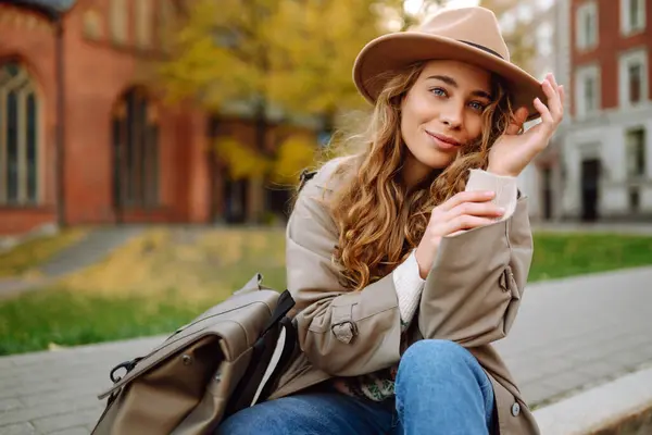 Seorang Wanita Bahagia Dengan Pakaian Santai Dan Topi Duduk Jalan — Stok Foto