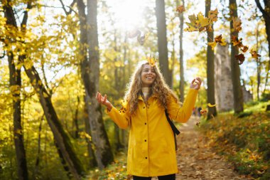Sırt çantalı aktif bir kadın sonbahar ormanında tahta merdivenlerde yürümekten hoşlanıyor. Bir turist dişi bir orman yolunda dağcılık yapıyor, eğleniyor, doğayı keşfediyor..