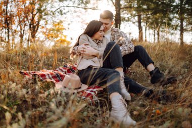 Genç bir erkek ve kadın sonbahar ormanlarında birlikte vakit geçirir, termostan sıcak bir içecek içer, yürür, doğanın tadını çıkarırlar. Tatil, doğada hafta sonu.