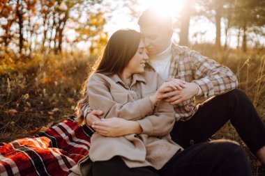 Genç bir erkek ve kadın sonbahar ormanlarında birlikte vakit geçirir, termostan sıcak bir içecek içer, yürür, doğanın tadını çıkarırlar. Tatil, doğada hafta sonu.