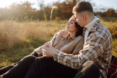 Genç bir erkek ve kadın sonbahar ormanlarında birlikte vakit geçirir, termostan sıcak bir içecek içer, yürür, doğanın tadını çıkarırlar. Tatil, doğada hafta sonu.