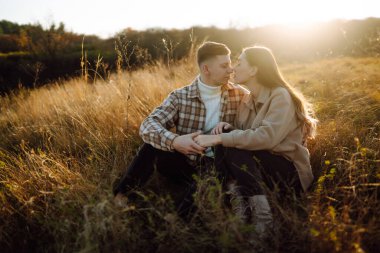 Genç bir erkek ve kadın sonbahar ormanlarında birlikte vakit geçirir, termostan sıcak bir içecek içer, yürür, doğanın tadını çıkarırlar. Tatil, doğada hafta sonu.