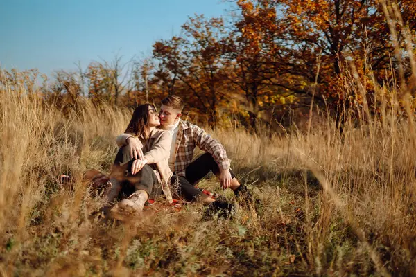 若い男性と女性は秋の森で一緒に時間を過ごし 熱湯からホットドリンクを飲み 散歩し 自然を楽しんでいます 自然の中で週末 — ストック写真