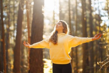 Aktif kadın, sonbahar ormanında sarı yaprakların arasında yoga yapıyor. Zen 'e yakalanıyor. Meditasyon kavramı, rahatlama. Etkin yaşam biçimi.
