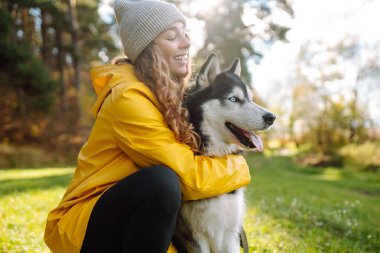 İri yapılı mutlu kadın yeşil bir çayırda yürüyor, eğleniyor. Evcil hayvanın sahibi birlikte zaman geçiriyor. Arkadaşlık kavramı, tatil, yürüyüş.