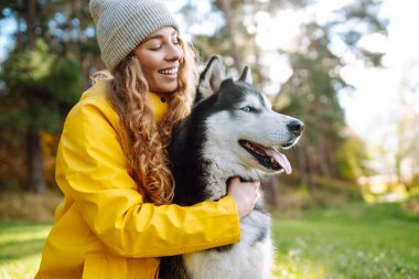 İri yapılı mutlu kadın yeşil bir çayırda yürüyor, eğleniyor. Evcil hayvanın sahibi birlikte zaman geçiriyor. Arkadaşlık kavramı, tatil, yürüyüş.