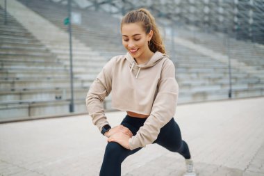Sokakta spor egzersizleri yapan güzel bir atletik kadın. Harika bir ruh hali. Spor ve sağlıklı yaşam tarzı konsepti
