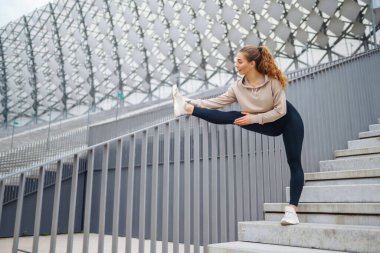 Sokakta spor egzersizleri yapan güzel bir atletik kadın. Harika bir ruh hali. Spor ve sağlıklı yaşam tarzı konsepti
