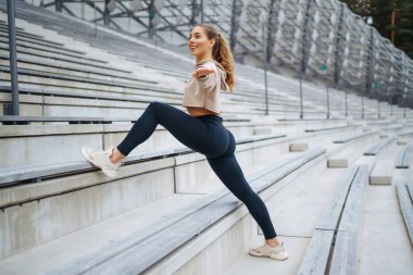 Sokakta spor egzersizleri yapan güzel bir atletik kadın. Harika bir ruh hali. Spor ve sağlıklı yaşam tarzı konsepti