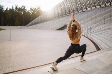 Sokakta spor egzersizleri yapan güzel bir atletik kadın. Harika bir ruh hali. Spor ve sağlıklı yaşam tarzı konsepti