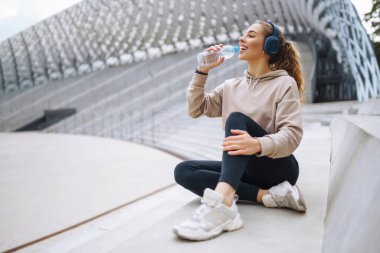 Sokakta spor egzersizleri yapan güzel bir atletik kadın. Harika bir ruh hali. Spor ve sağlıklı yaşam tarzı konsepti