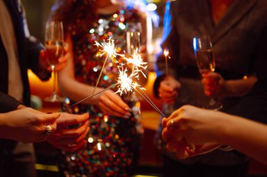 Ellerinde pırıl pırıl parlıyor. Bir grup mutlu insan havai fişeklerle eğleniyor. Kış tatili.