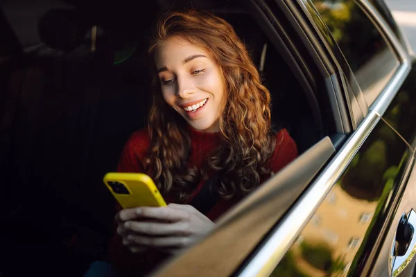 Wanita Tersenyum Dalam Mobil Taksi Dengan Ponsel Tangannya Konsep Transportasi — Stok Foto
