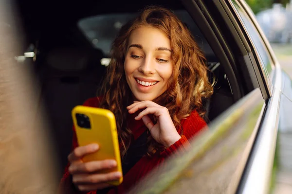 Wanita Tersenyum Dalam Mobil Taksi Dengan Ponsel Tangannya Konsep Transportasi — Stok Foto