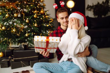 Noel ağacının yanında birbirine aşık güzel bir çift, hediye alışverişini kutluyorlar, birlikte vakit geçiriyorlar. Tatil kavramı.