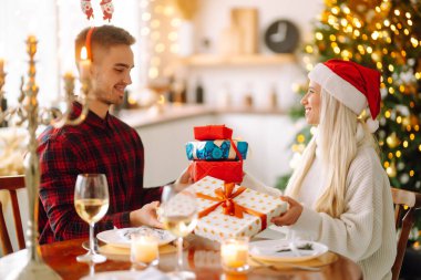 Noel ağacının yanında birbirine aşık güzel bir çift, hediye alışverişini kutluyorlar, birlikte vakit geçiriyorlar. Tatil kavramı.