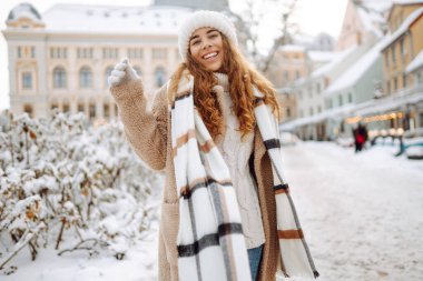 Mutlu bir kadın kışın soğuk bir sabahta karlı bir sokakta eğleniyor. Genç bir kadın bir kış günü şehirde yürür. Yürüyüş kavramı, hafta sonları.