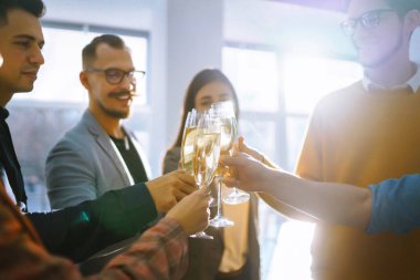 Ofisteki meslektaşlarımız şampanya ve köpüklü şarapla sonuçlanan anlaşmayı kutluyor. Şampanya bardaklı bir grup insan ofiste eğleniyor, dinleniyor. İş kavramı, tatil..