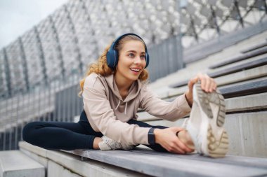 Atletik genç bayan dışarıda antrenman yapıyor. Spor salonundaki kadın dışarıda geriniyor. Aktif yaşam tarzı konsepti, spor.