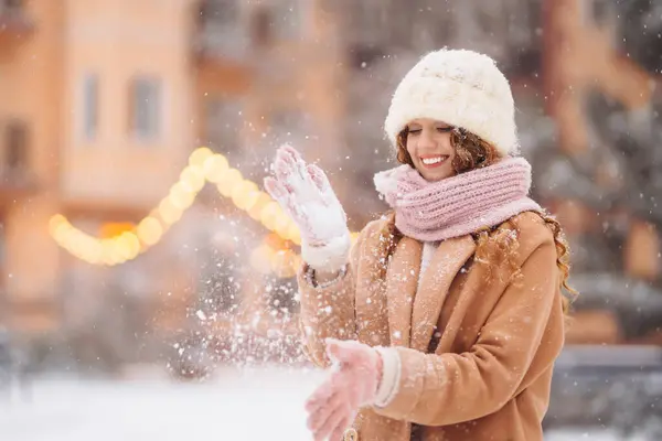 一个甜美的女人沿着装饰过的街道走着 卷曲的女人享受着降雪 寒假在户外 假日概念 — 图库照片