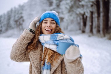 Güzel genç bir kadın yeni yıl fuarında eğleniyor ve selfie çekiyor. O bir kürk manto, şapka ve eşarp giydi. Harika bir yeni yıl havası. Tatil konsepti, hafta sonları, rahatlama.. 