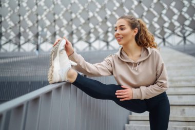 Açık havada güzel bir kadın ve spor kıyafetleri spor yapıyor. Güneşli bir günde atletik kadın antrenmanı. Spor anlayışı, eğlence..