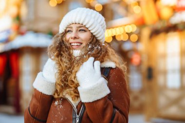 Mutlu kadın kış Noel pazarında eğleniyor. Genç bir turist güneşli bir kış gününde Yeni Yıl atmosferinin tadını çıkarıyor. Tatil kavramı, rahatlama..